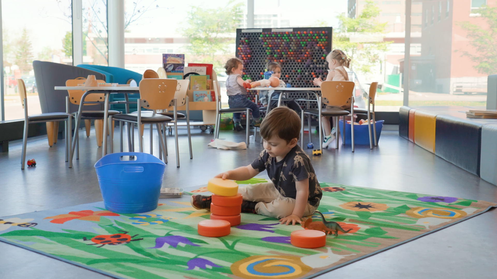 Enfant jouant avec des jouets sur un tapis dans une garderie